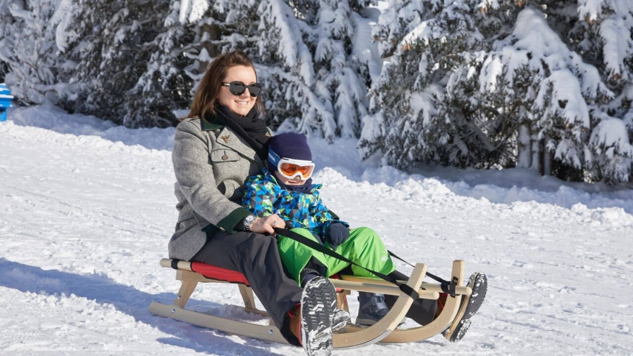 Frau mit Kind beim Rodeln