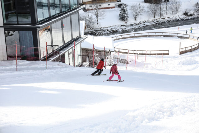 Zwei Skifahrer im Schnee, sonniger Tag.