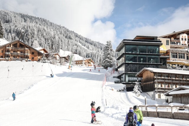 Skigebiet mit verschneiten Pisten und Hütten.