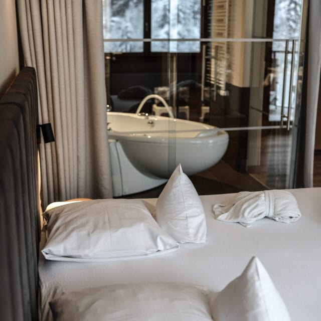 Gemütliches Bett mit Blick auf Badezimmer.