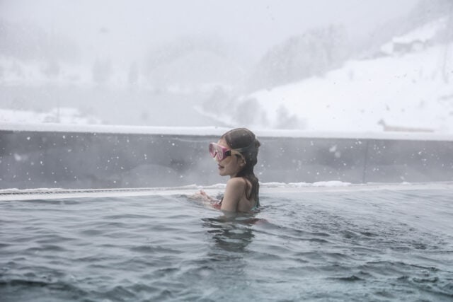 Mädchen schwimmt im Winter im Pool.