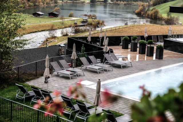 Entspannungsbereich mit Liegen und Poolblick