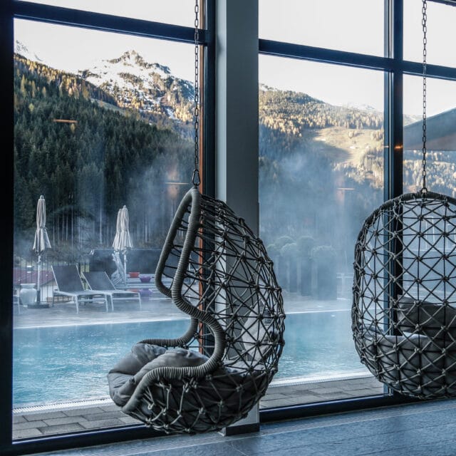 Gemütliche Hängesessel mit Blick auf pool und Berge.
