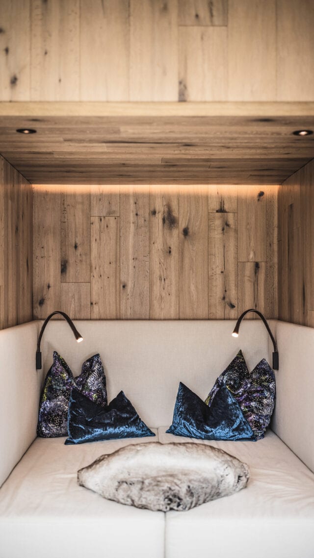 Gemütliche Ecke mit Kissen und Holzdetails.