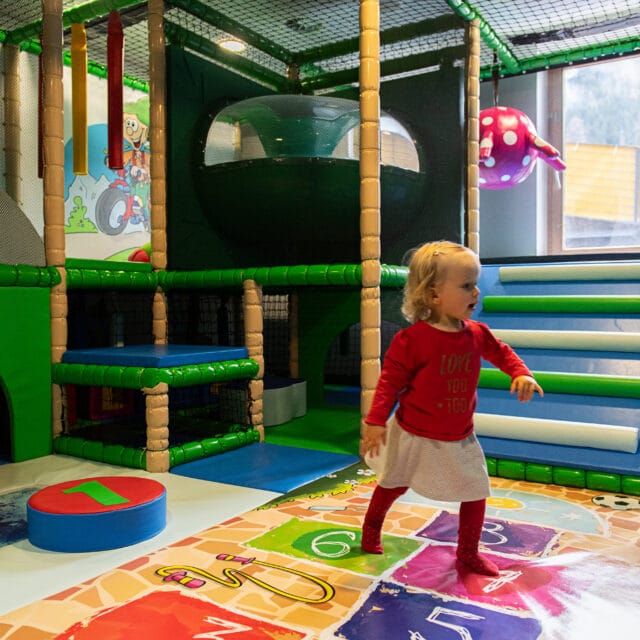 Kind spielt im bunten Indoor-Spielbereich.