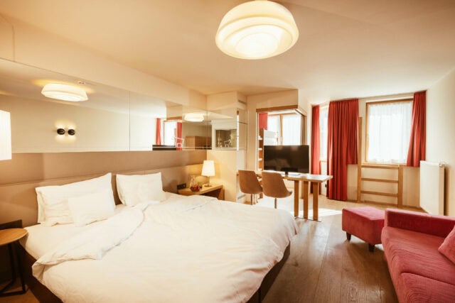 Helles Zimmer mit Bett und TV-Bereich