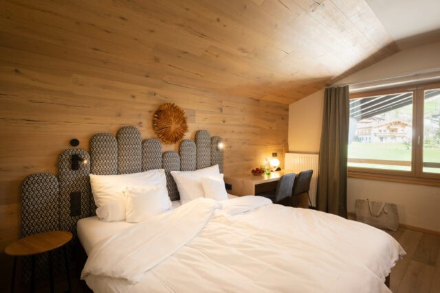 Gemütliches Schlafzimmer mit Holzwänden und Aussicht