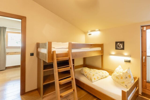 Gemütliches Schlafzimmer mit Hochbett und Holzdetails