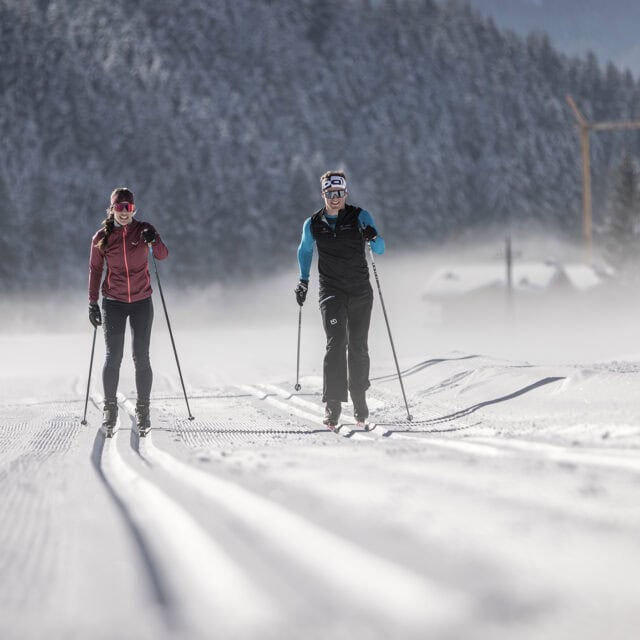 Langläufer im schneebedeckten Winterwald