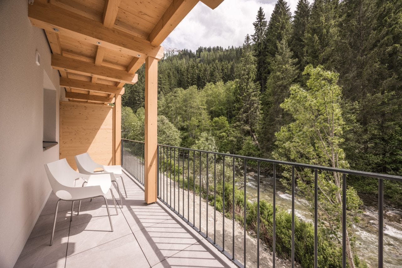 mitarbeiter team lodge balkon mit aussicht bach und wald